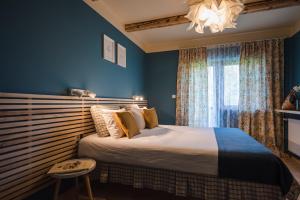 a bedroom with a bed with blue walls and a chandelier at La Mesteceni & Loc cu Stări de Bine, SPA adult only in Sălicea