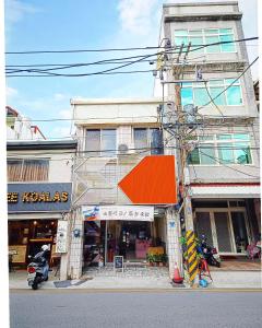 un bâtiment avec un toit orange dans une rue dans l'établissement 博愛泊旅讀心境, à Hualien