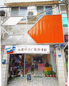 un magasin devant un bâtiment avec un toit orange dans l'établissement 博愛泊旅讀心境, à Hualien