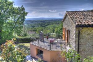 a stone house with a balcony with a view at Villa delle lucciole in Massa Martana