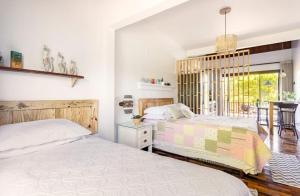 瓜德丁堡的住宿－Refugio Na Praia Hospedagem - Guarda Do Embaú，一间带两张床的卧室和一间餐厅
