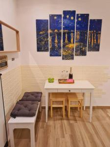 uma sala de jantar com uma mesa e algumas pinturas na parede em Casa Sorelle Marchisio em Roma