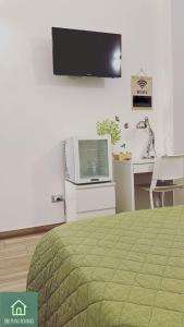 1 dormitorio con 1 cama y TV en la pared en B&B Piano Romano -con parcheggio privato gratuito- en Foggia