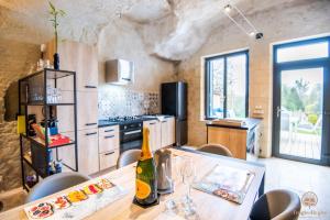 a kitchen with a table with a bottle of wine at Troglo Dit Gîte 4* proche d'Amboise in Nazelles