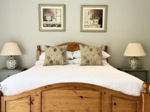 um quarto com uma cama de madeira e 2 candeeiros em Farthings Country House Hotel & Restaurant Tunton em Taunton