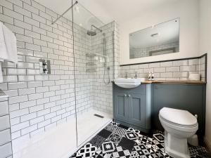 La salle de bains est pourvue de toilettes, d'un lavabo et d'une douche. dans l'établissement Farthings Country House Hotel & Restaurant Tunton, à Taunton