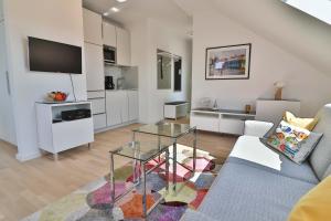 a living room with a couch and a glass table at Lüttjeod - Apartment 17 in Langeoog