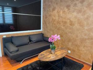a living room with a couch and a table with flowers at Appartement cosy terrasse parking 20 mn Paris in Savigny-sur-Orge