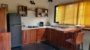 a kitchen with wooden cabinets and a refrigerator at Cabina Brisa Escondida - Walking distance from river in Savegre