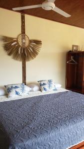 a bedroom with a blue bed with a ceiling fan at Cabina Brisa Escondida - Walking distance from river in Savegre
