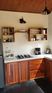 a kitchen with wooden cabinets and a stove top oven at Cabina Brisa Escondida - Walking distance from river in Savegre