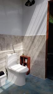 a bathroom with a white toilet and a sink at Cabina Brisa Escondida - Walking distance from river in Savegre
