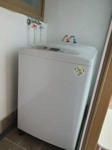 Elle comprend un réfrigérateur blanc avec un évier. dans l'établissement Cozy accomodation near chilgok gyeongdae hospital, à Daegu