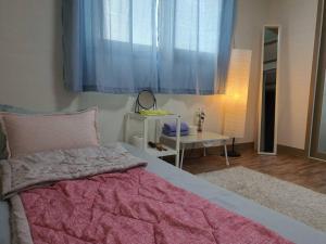 大邱的住宿－Cozy accomodation near chilgok gyeongdae hospital，一间卧室配有一张大床和一张桌子