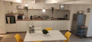 a kitchen with a white table and yellow chairs at CaSaMaS Spacious 75m Apartment in Brindisi Historic Center Rated 9 in Brindisi