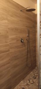a shower with a shower head on a wooden wall at CasaMas in Brindisi