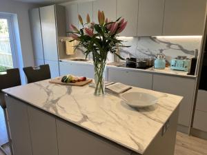 a kitchen with a vase of flowers on a counter at Oakwood in Lymington