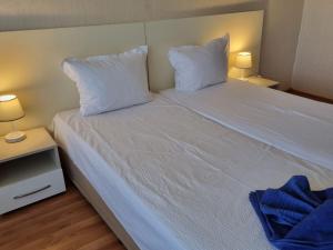 a bedroom with a white bed with two pillows at Danube Park in Ruse