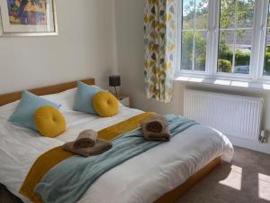 a bedroom with towels on a bed with a window at Oakwood in Lymington