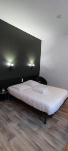 duże łóżko w pokoju z czarną ścianą w obiekcie Guest Home location w mieście Néris-les-Bains