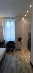 um quarto com uma cama, uma cadeira e uma janela em Guest Home location em Néris-les-Bains