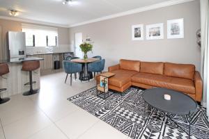 uma sala de estar com um sofá e uma mesa em White Orchid Luxury Apartment em Chartwell