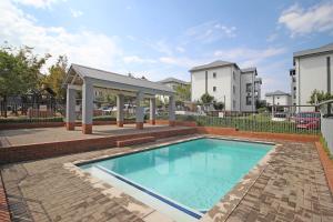 a swimming pool with a pavilion and a building at White Orchid Luxury Apartment in Chartwell