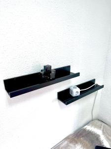 a black shelf on a wall with a camera at Las habitaciones de Svetlana in Alicante
