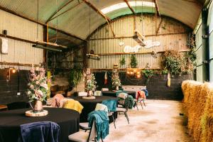 een kamer met tafels en stoelen met planten bij Fitz Of Inch - Self Catering House and Barns in Stradbally