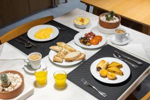 a table with plates of breakfast food on it at Evora Olive Hotel in Évora