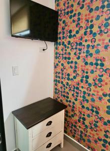 eine Kommode in einem Zimmer mit einer farbenfrohen Wand in der Unterkunft La Calma Poshtel in San Juan