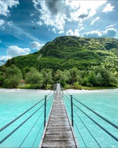 a wooden bridge over a body of water at Apartment Joži in Soča