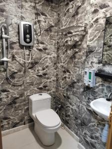 a bathroom with a toilet and a sink at Tang Hotel in Alor Setar