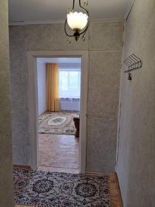 um corredor vazio com uma porta que leva a uma casa de banho em Квартира улица Абая 18 em Borovoye