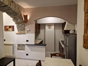 una cocina con un arco de piedra y una mesa en Casa Romantica Tra Liguria e Toscana, en Ortonovo