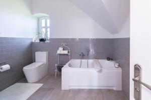 uma casa de banho com uma banheira branca e um WC. em Dom nad Rzeką em Raciechowice
