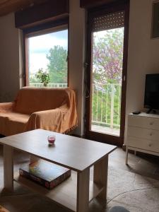 un soggiorno con tavolino e finestra di Goldberg - Apartman Lana a Popovac
