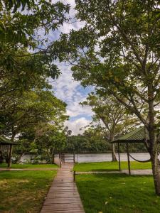 a wooden path through a park next to a body of water at Lençóis Confort - Apartamento in Barreirinhas
