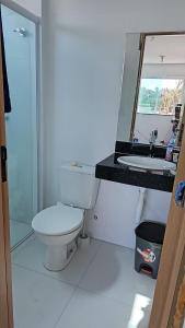 a bathroom with a toilet and a sink and a mirror at Lençóis Confort - Apartamento in Barreirinhas