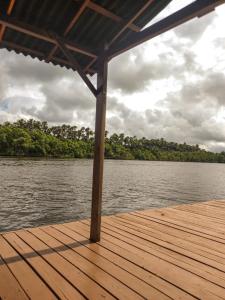 un muelle de madera sobre un cuerpo de agua en Lençóis Confort - Apartamento, en Barreirinhas