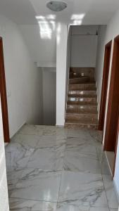 an empty room with a marble floor and stairs at Vanessi in Dugi Rat
