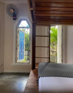 1 dormitorio con cama y ventana en Habibi Hostel & Restaurant en Unawatuna