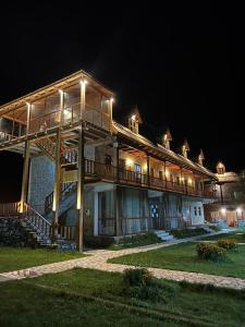 a large building with a deck at night at Logu i Harushave in Theth