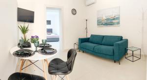 Cosmo apartment في دوبروفنيك: غرفة معيشة مع أريكة زرقاء وطاولة