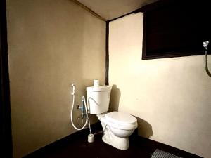 a bathroom with a white toilet in a room at The Hidden Gem in Ban Nok