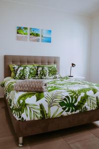 a bedroom with a bed with a green and white comforter at The Palm Leaf Apartments in Noord