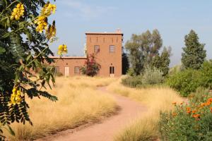 a dirt road in front of a brick building at Dar Tasmayoun in Aït Ourir