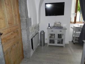 een woonkamer met een open haard en een flatscreen-tv bij Charmant gîte 2 étoiles, parking privé à Ruoms in Ruoms