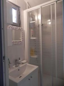 een witte badkamer met een wastafel en een douche bij Charmant gîte 2 étoiles, parking privé à Ruoms in Ruoms