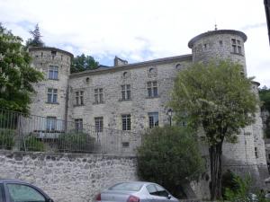 een oud stenen gebouw met een auto ervoor geparkeerd bij Charmant gîte 2 étoiles, parking privé à Ruoms in Ruoms